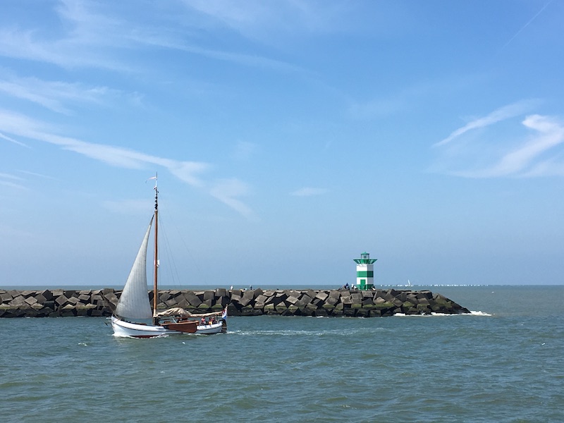 Un bateau passe à côté d'un phare métaphore du fait de garder le cap de sa vie